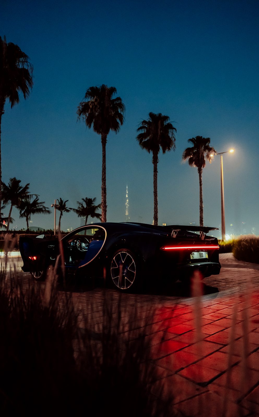 Bugatti Chiron beneath the palms with the Burj Khalifa on the horizon