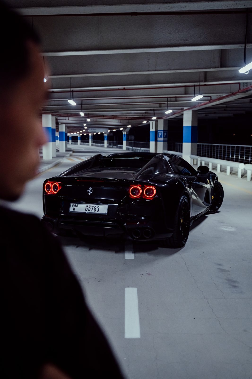 Black Ferrari 812 GTS in a Dubai parking garage at night
