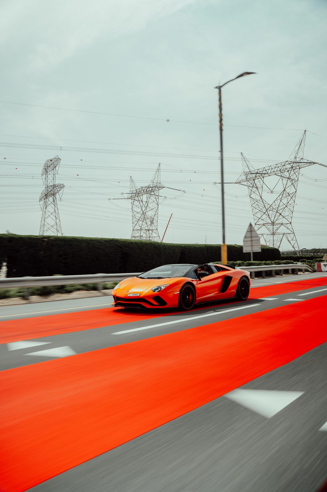 Orange Lamborghini Aventador S Roadster on Dubai's red-surfaced highway