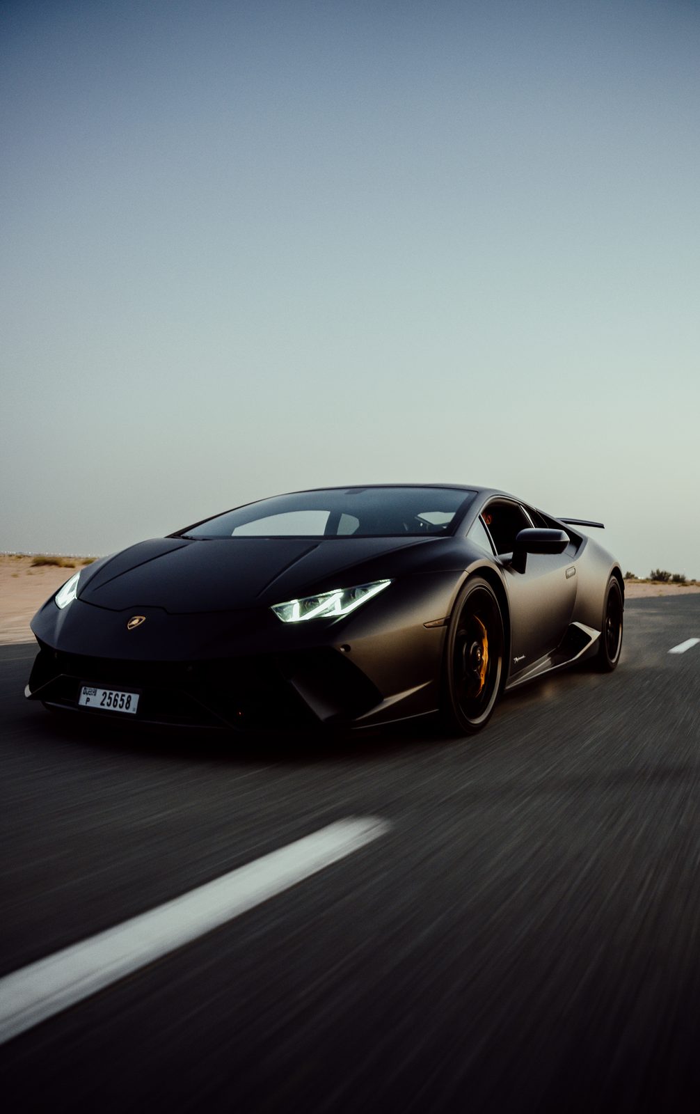 Matte black Lamborghini Huracán Performante with gold wheels on a desert road