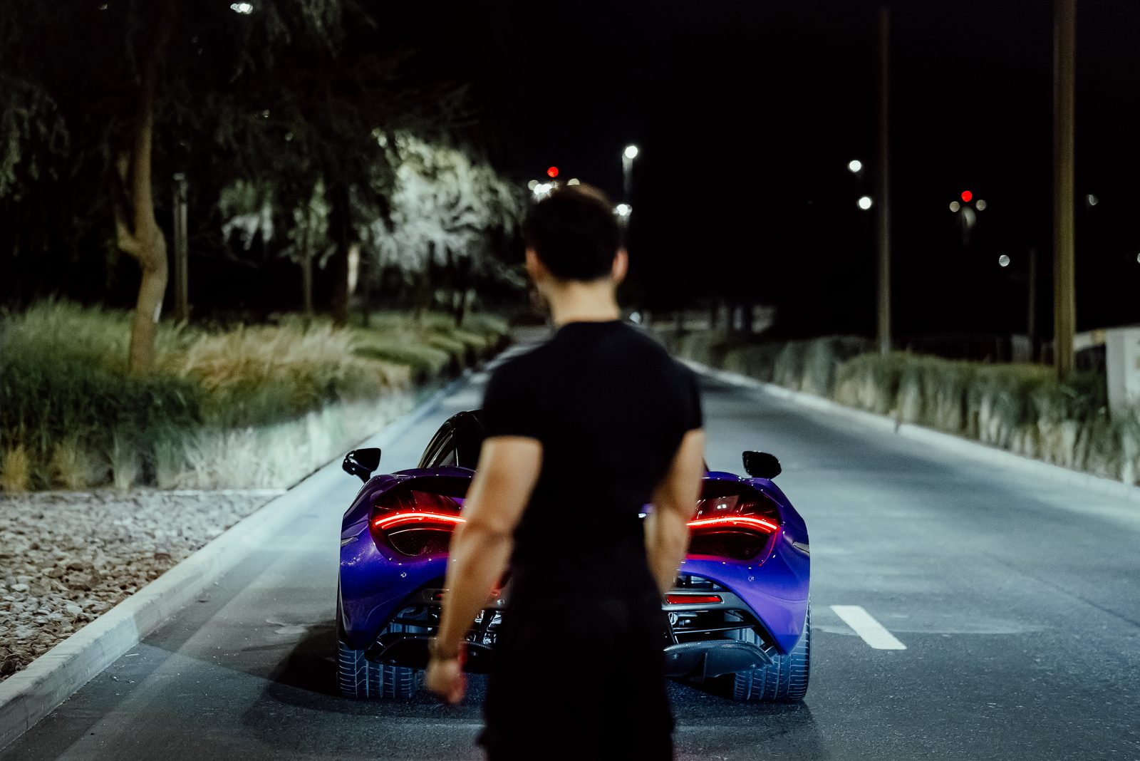 Purple McLaren 720S on a tree-lined Dubai road at night
