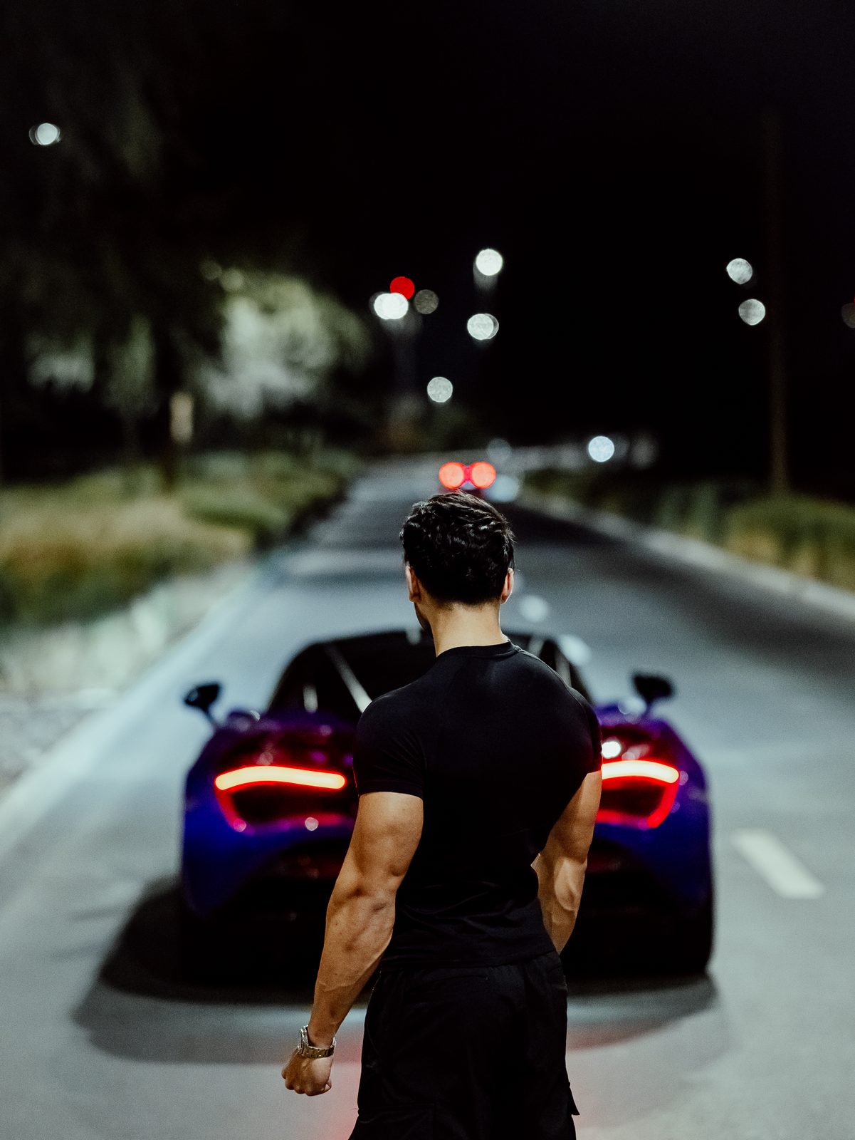 Owner facing his purple McLaren 720S under the streetlights
