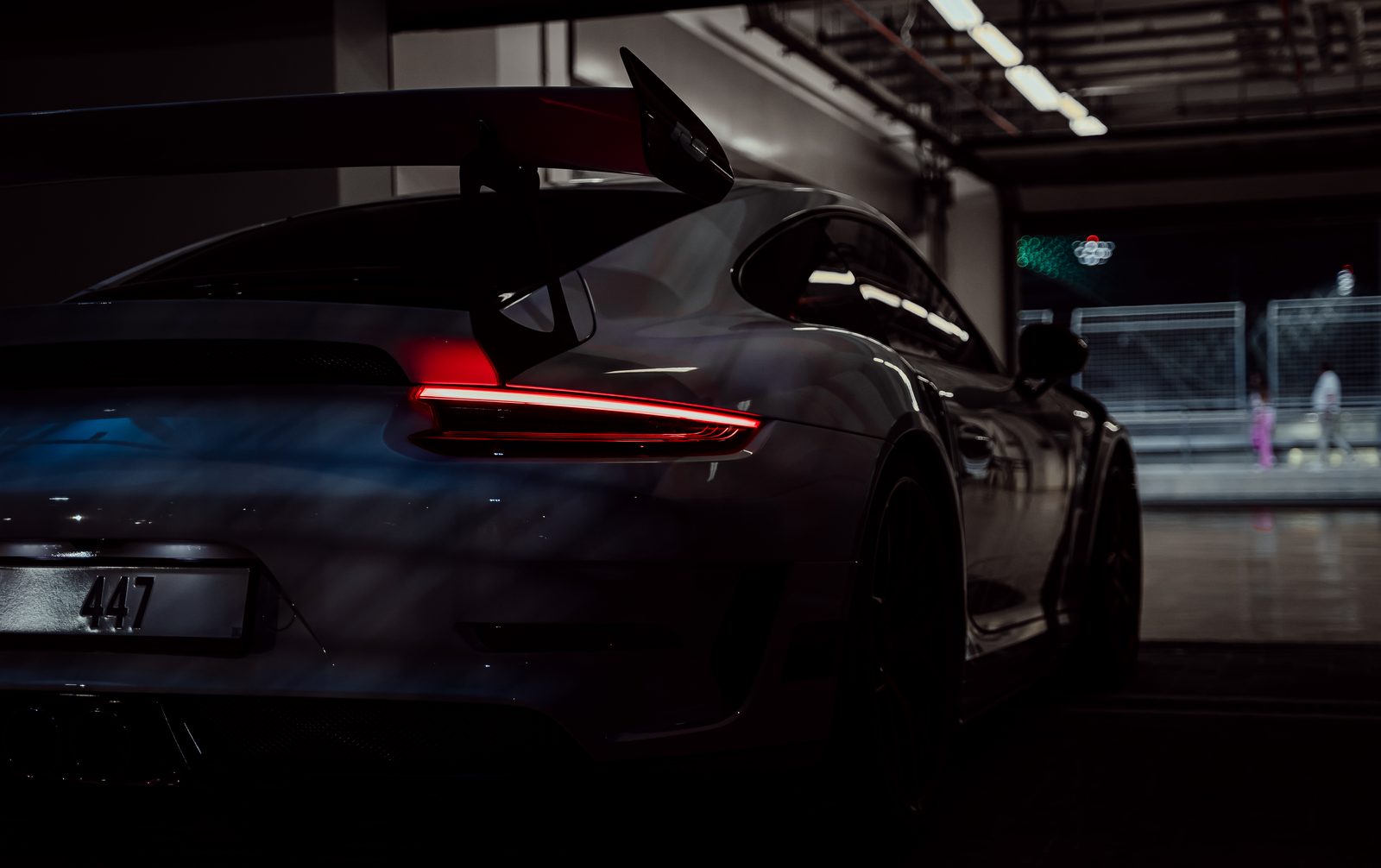 White Porsche 911 GT3 RS rear wing under garage light