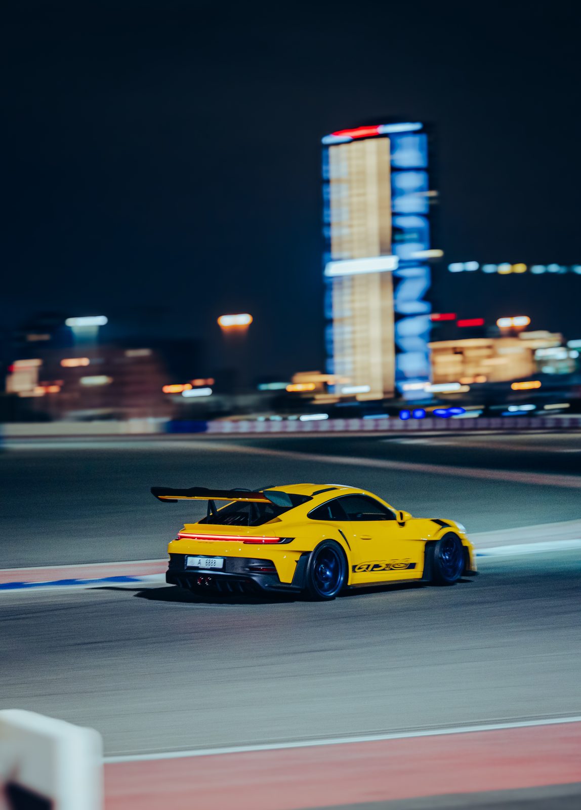 Yellow Porsche 911 GT3 RS on track at Dubai Autodrome at night