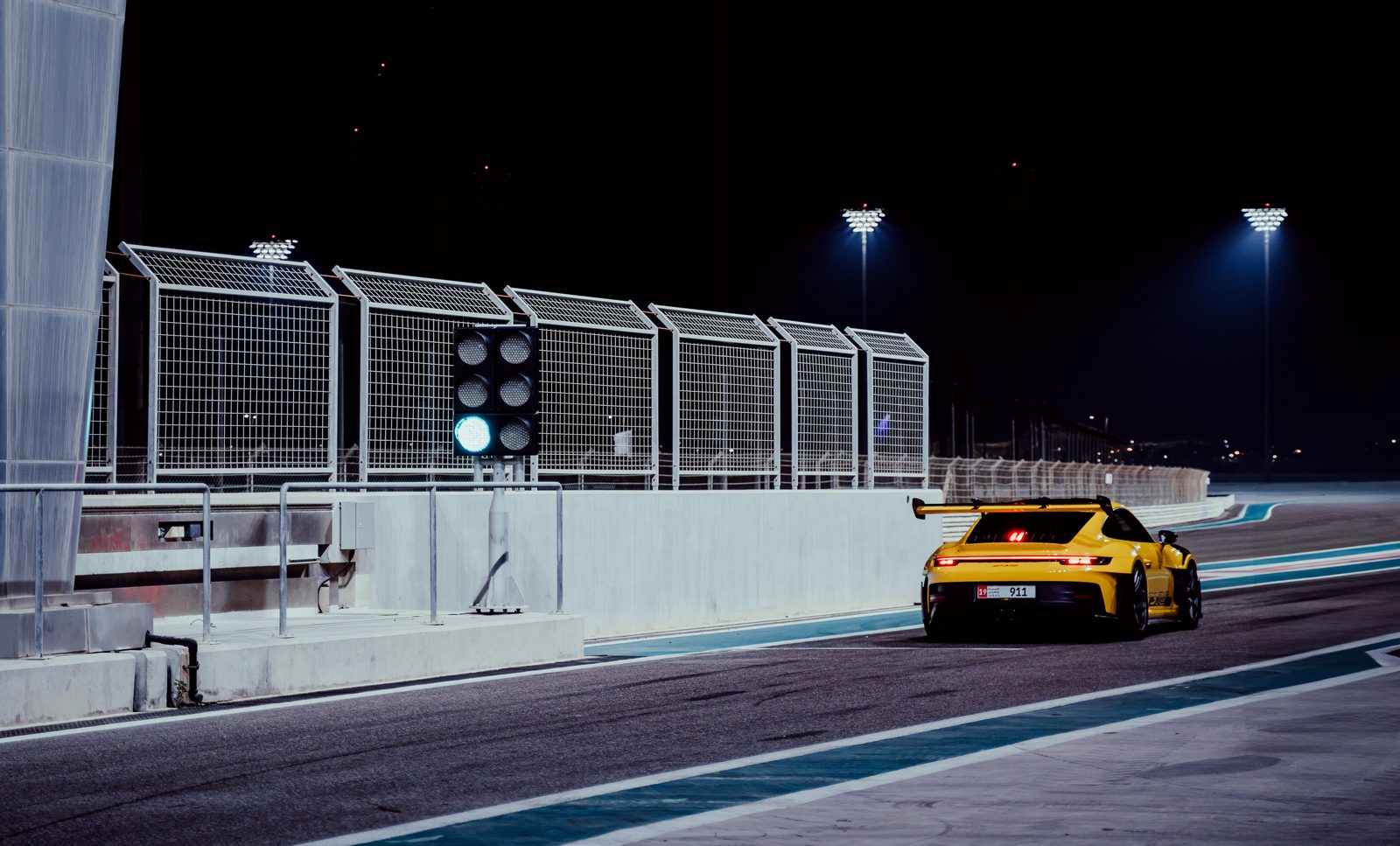 Yellow Porsche 911 GT3 RS leaving the pit lane at Yas Marina